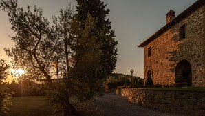 Un edificio de piedra de estilo arquitectónico rústico, con una entrada en arco y una pequeña torre.