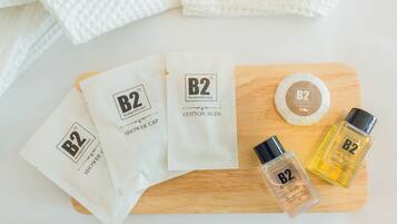 A wooden tray with B2 shower cap, cotton buds, and B2 bath & shower gel.