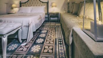 A traditional bedroom with a bed, bedside tables, a nightstand, a lamp, and a lantern.