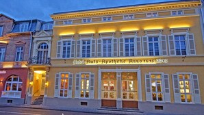 Un bâtiment jaune avec une enseigne indiquant : « Hôtel Route-Apostrophe, rue 1615 ».