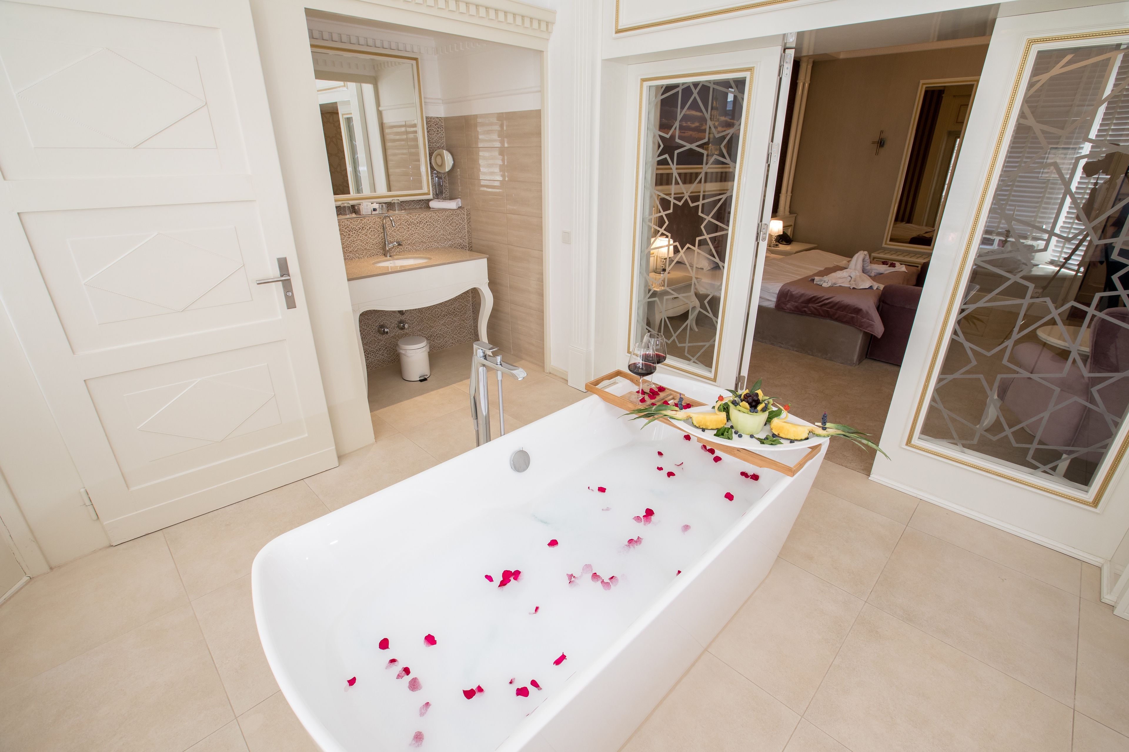 A modern bathroom with a large bathtub, a sink, and a mirror.
