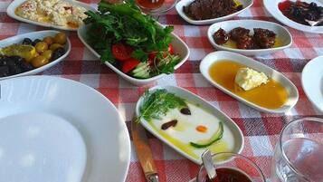 A table with various dishes and a glass of tea.