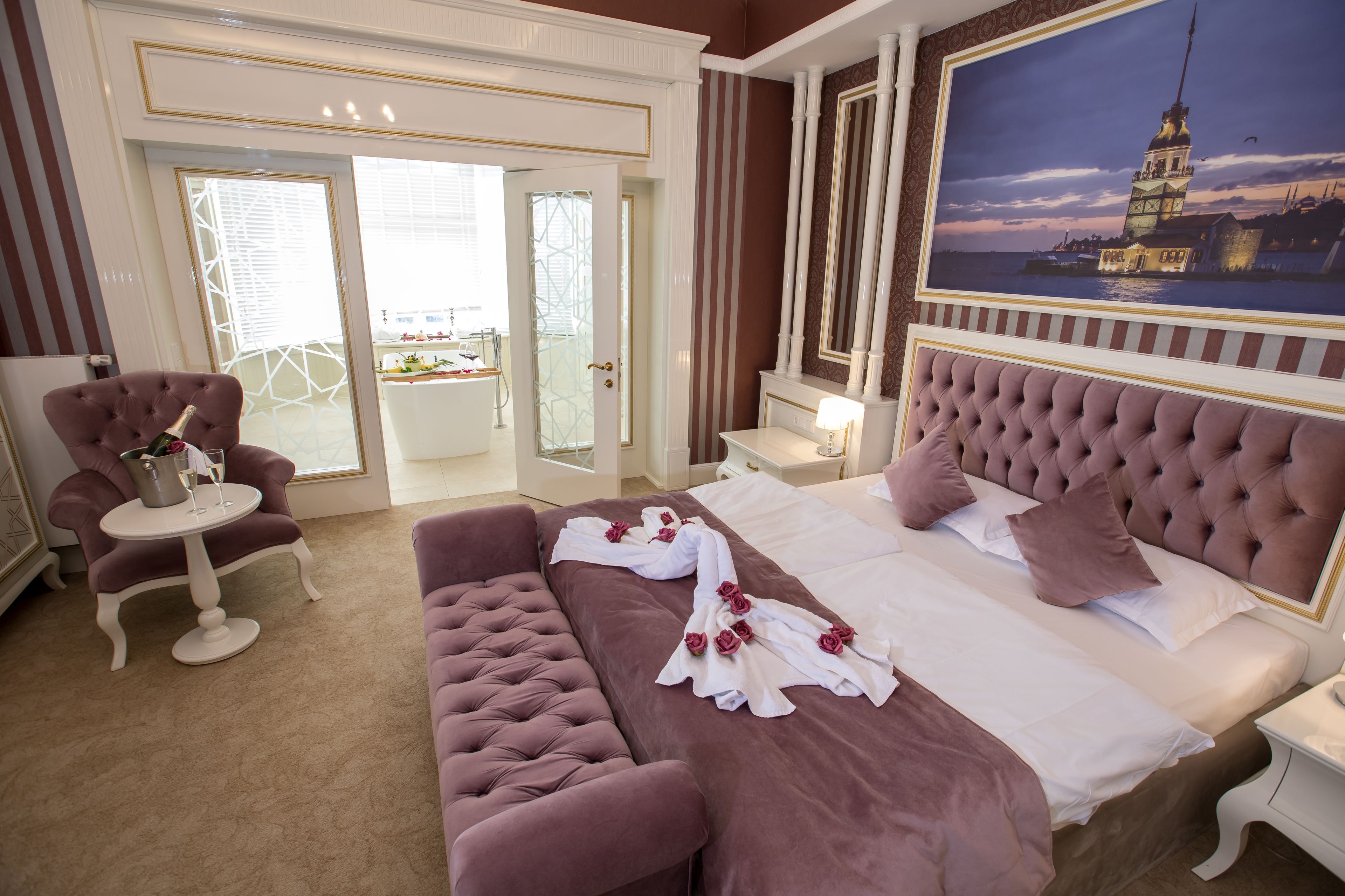 Um quarto luxuoso com uma cama grande, um espaço de estar e vista para a cidade.