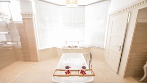 Une salle de bain moderne avec une baignoire sur pieds, un meuble-lavabo avec un miroir et un espace douche.