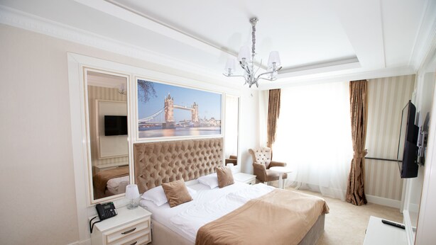 Une chambre d’hôtel avec un grand lit, une télévision, un bureau et une chaise.