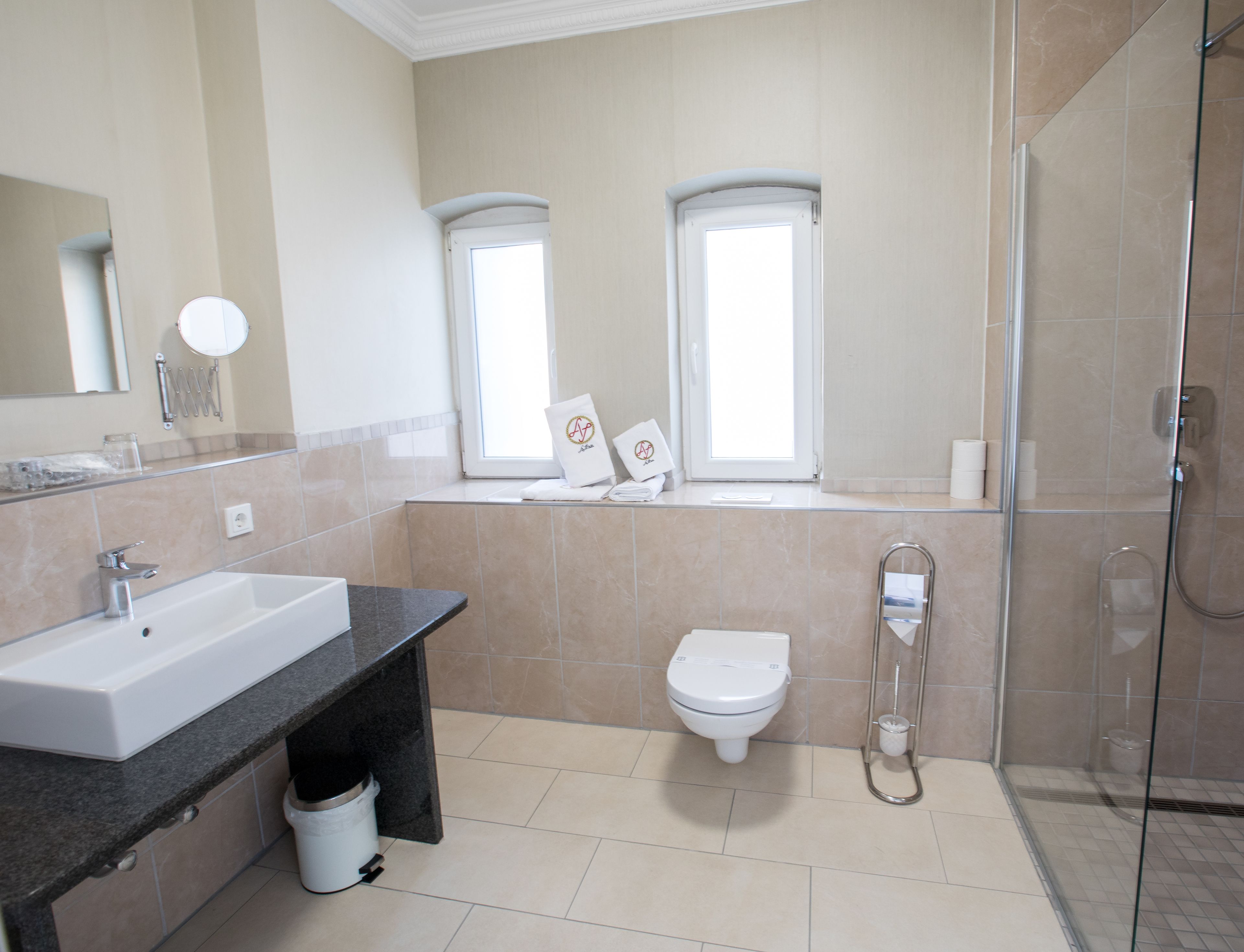 A modern bathroom with a sink, toilet, and shower.