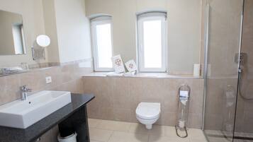 A modern bathroom with a sink, toilet, and shower.