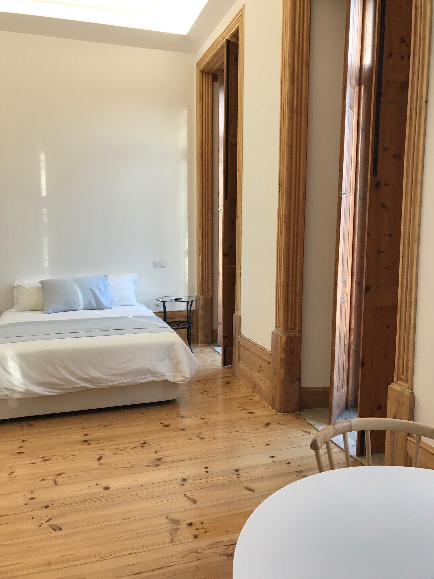 Una camera da letto con un letto, un tavolino e pavimento in legno.