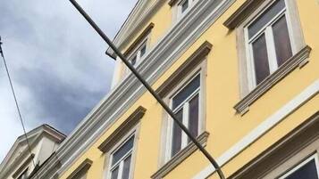 Un edificio amarillo con varias ventanas y un farol en la calle.
