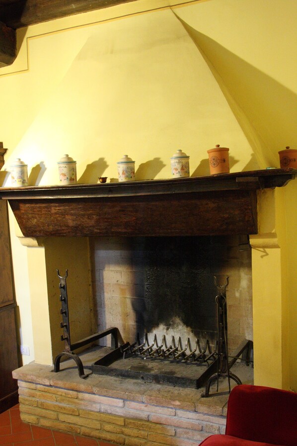 A fireplace with a brick base and a wooden mantel.