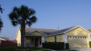 A single-story house with a garage, a front porch, and a palm tree. - Ly53793 - Indian Ridge - 3 Bed 2 Baths Villa (Kissimmee)