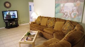 A living room with a brown sofa, a coffee table, and a television on a stand. - Ly53798 - Indian Ridge - 4 Bed 2 Baths Villa (Kissimmee)