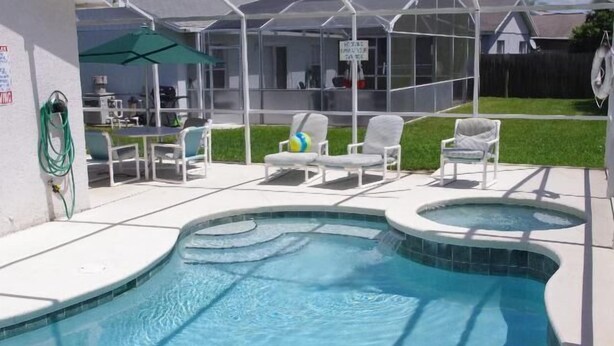 A swimming pool with two hot tubs, surrounded by white lounge chairs and a covered patio area. - Ly53798 - Indian Ridge - 4 Bed 2 Baths Villa (Kissimmee)