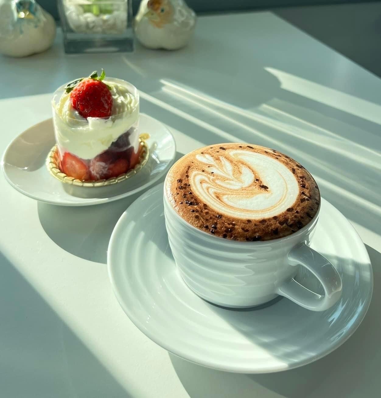 Un dessert e una tazza di caffè su un tavolo bianco.
