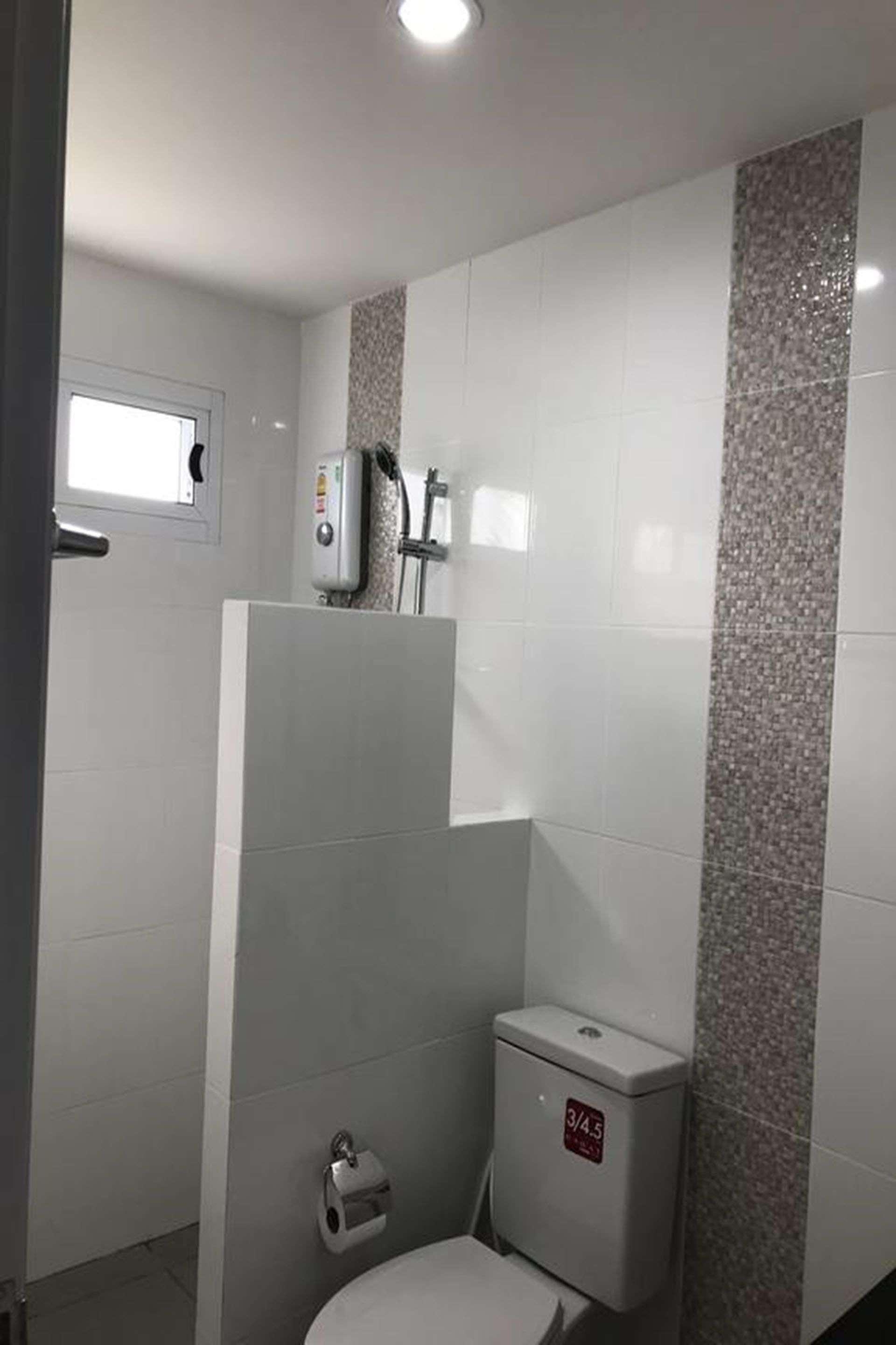 Un bagno con il water, una doccia e un asciugamani ad aria.