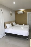 Una habitación de hotel con una cama doble, una mesita de noche y aire acondicionado instalado en la pared.