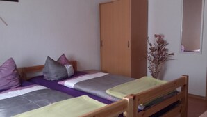 A single bed with a wooden headboard, a wooden wardrobe, and a mirror on the wall. - Restaurant Pension Lubusch Gahro (Crinitz)