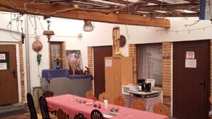 A dining area with a red checkered tablecloth, wooden chairs, and a rustic ceiling. - Restaurant Pension Lubusch Gahro (Crinitz)