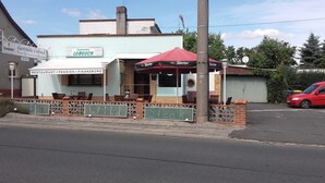 A restaurant with outdoor seating, a red umbrella, and chalkboard signs advertising 'Steak' and 'Wild'. - Restaurant Pension Lubusch Gahro (Crinitz)