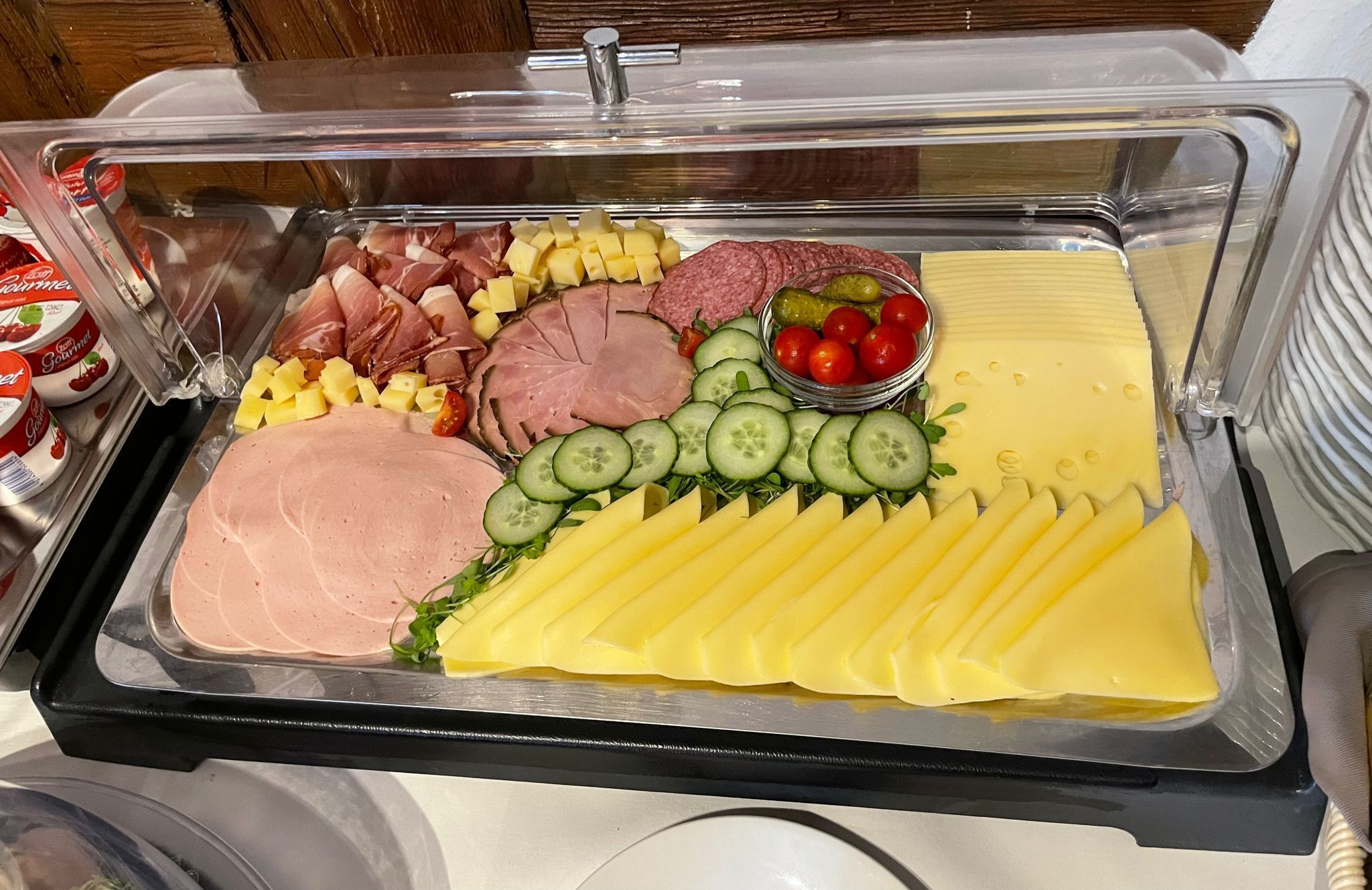 A buffet with various food items including meats, cheeses, and vegetables.