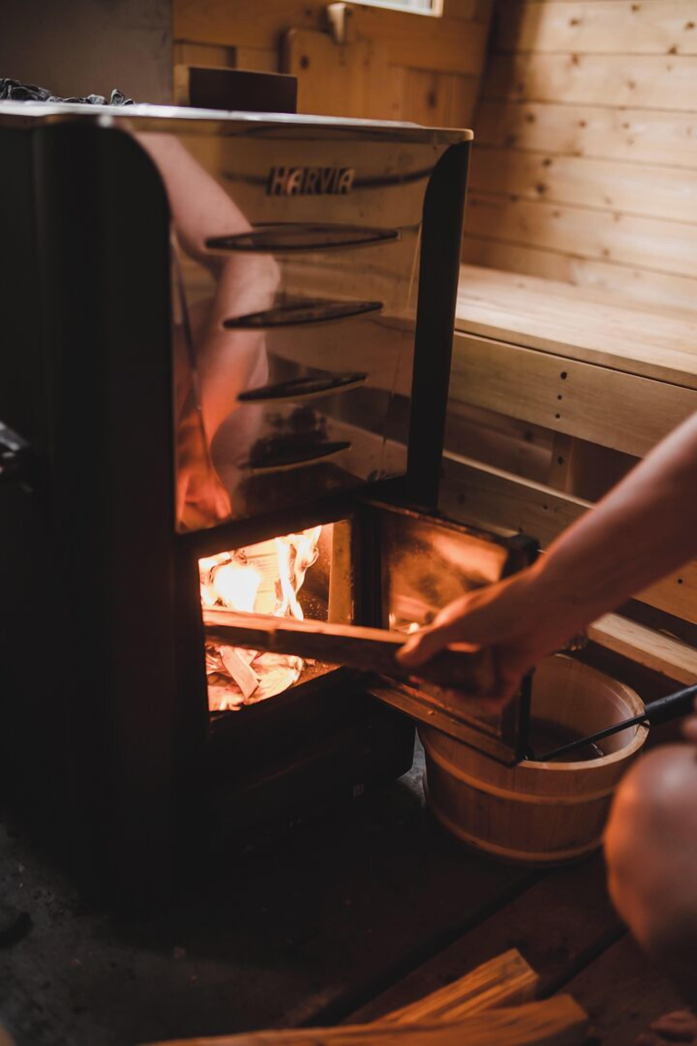 Un poêle à bois avec une personne qui s'en occupe.