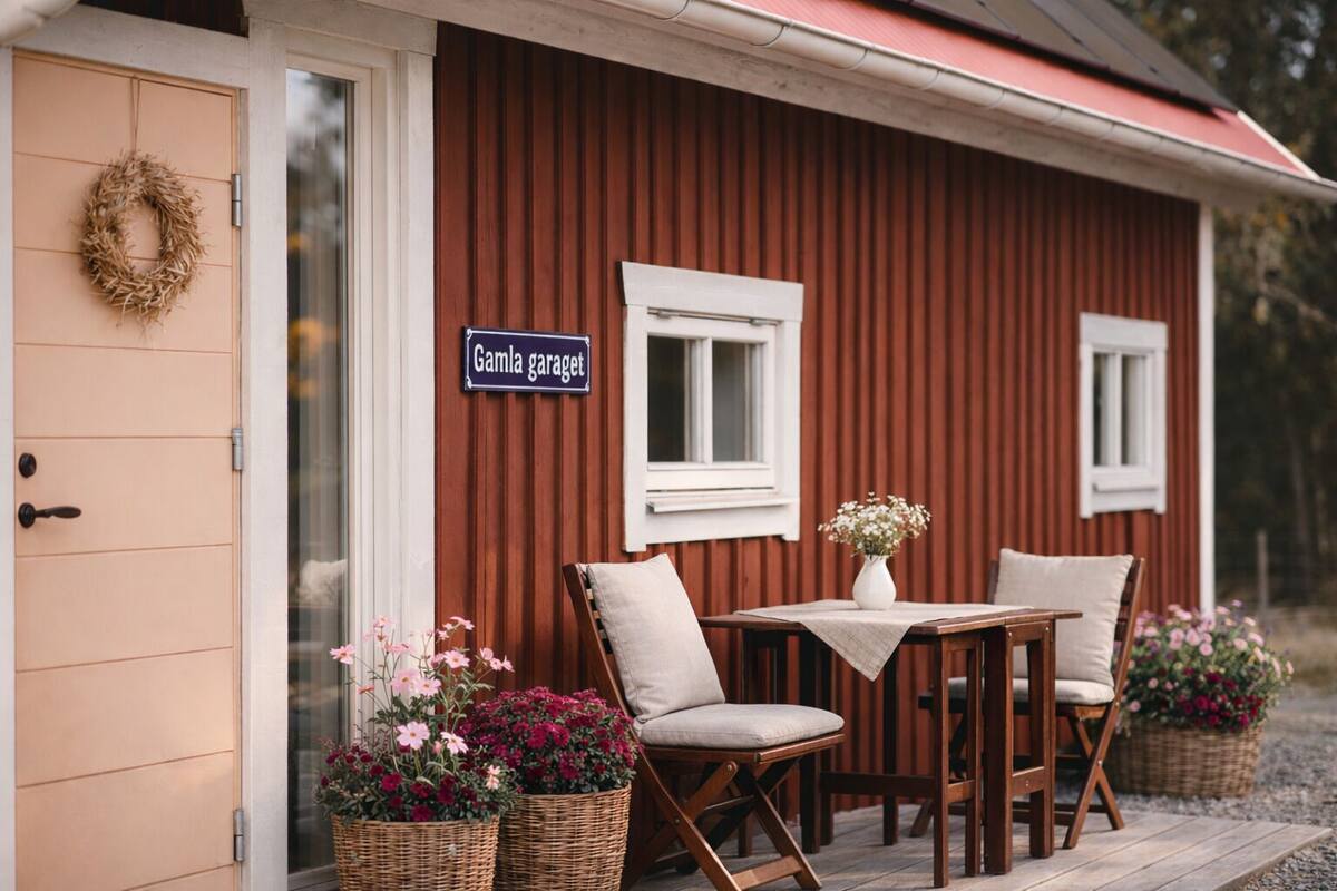 A small wooden cabin with a sign reading "Gamlagarettet" and a table with chairs outside.