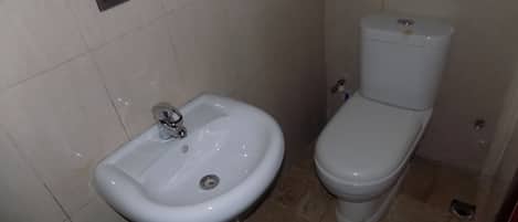 A bathroom with a white sink and toilet.