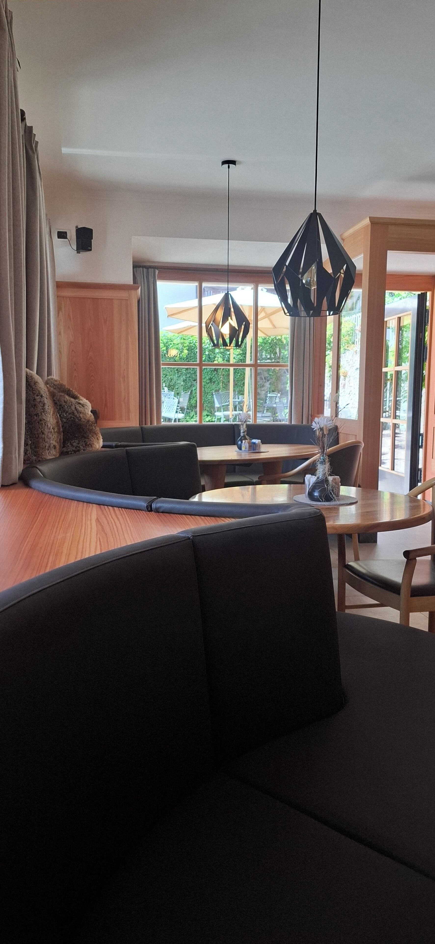 Una sala de estar moderna con un sofá, una mesa de comedor y un amplio ventanal con vistas al verdor.