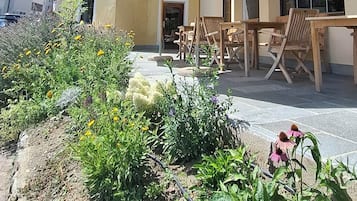 Un bâtiment doté d’un balcon, d’un espace extérieur aménagé pour s’asseoir et d’un jardin.