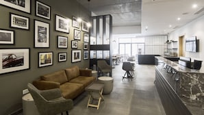 A modern interior with a sofa, chairs, a marble counter, and framed pictures on the walls. - Mr. Todd Hotel (Sliema)