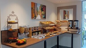 Un buffet de petit-déjeuner proposant une variété d’aliments et de boissons, notamment des fruits, des viennoiseries et du café.