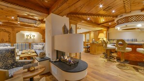 A cozy, wood-paneled room with a fireplace, seating area, and a bar. - Romantik Landhotel Doerr (Bad Laasphe)