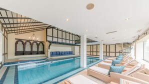 A swimming pool with lounge chairs and a seating area with a view of the pool. - Romantik Landhotel Doerr (Bad Laasphe)