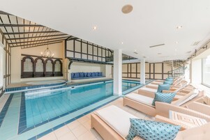 Una piscina con sillas de descanso y un área de estar con vistas a la piscina.