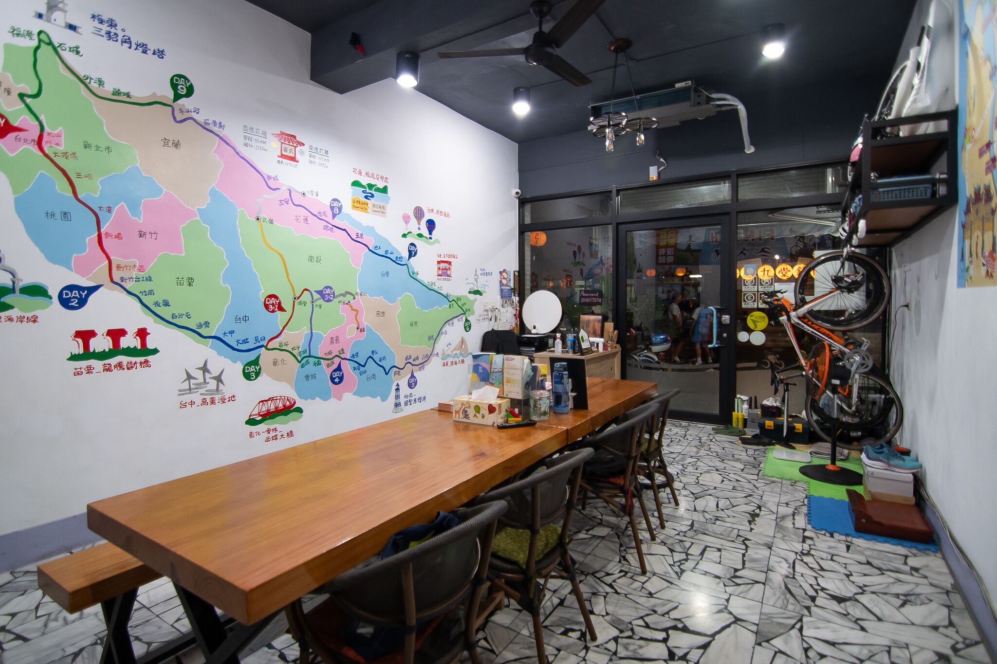 Uma sala de conferências com um grande mapa na parede, uma mesa de madeira e cadeiras.