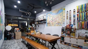 A café with a wooden table and benches, a bicycle rack, and a wall with a map and various items.