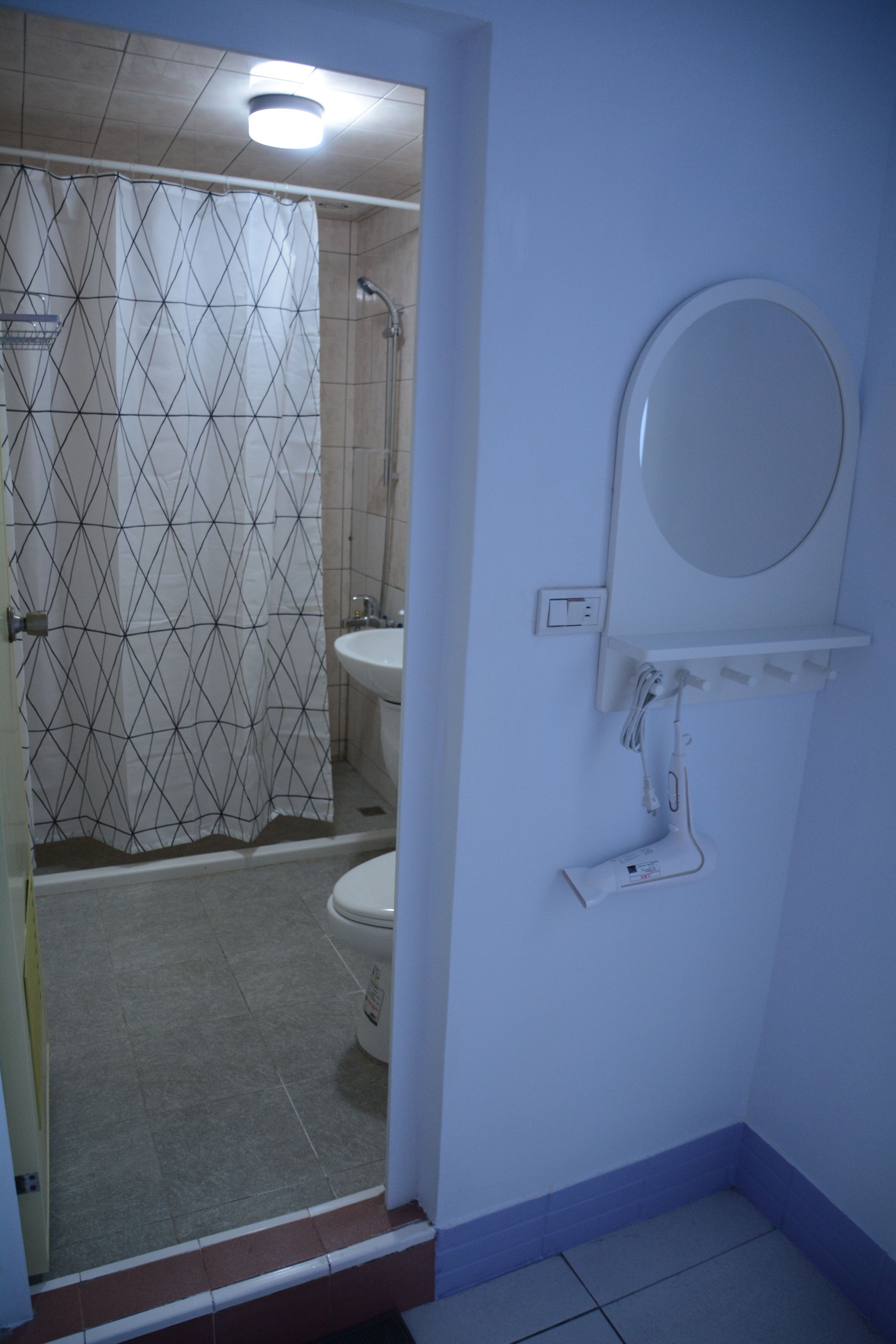 A bathroom with a shower, toilet, and sink.