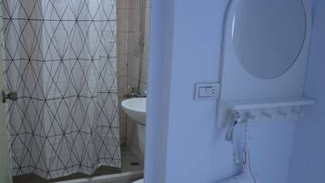 Un baño con ducha, inodoro y lavabo.
