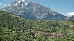 Un paysage montagneux avec un village niché au fond de la vallée.