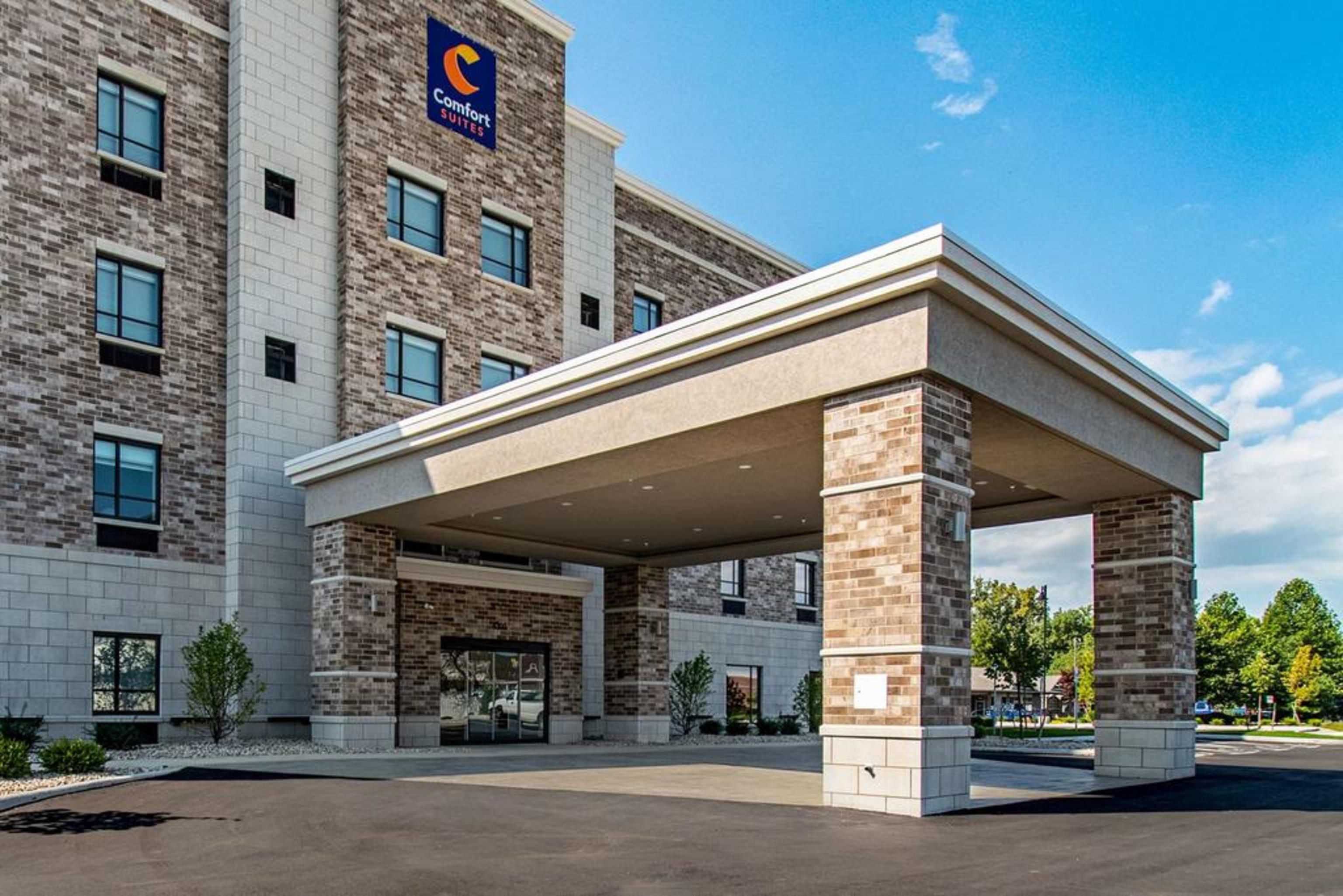 A Comfort Suites hotel with a covered entrance and brick facade.