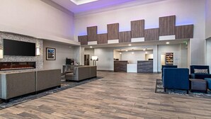 Eine großzügige Lobby mit Kamin, Sitzbereich und einer Rezeption.