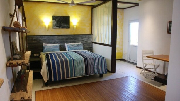 A bedroom with a bed, a desk, a chair, a ceiling fan, and a window. - Tom's Garden (Senya Beraku)