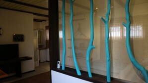 A room with a glass partition featuring abstract blue tree-like structures. - Tom's Garden (Senya Beraku)