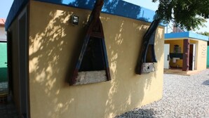 A yellow building with two windows and a blue roof. - Tom's Garden (Senya Beraku)