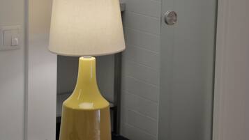 A small table with a yellow lamp and a telephone.