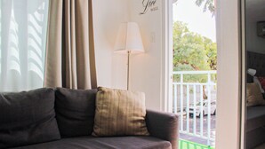 Un salón con sofá, una lámpara y vistas al exterior.