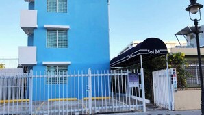 A blue building with a white fence and a sign reading "S0126". - Chandelier 302 (Ponce)