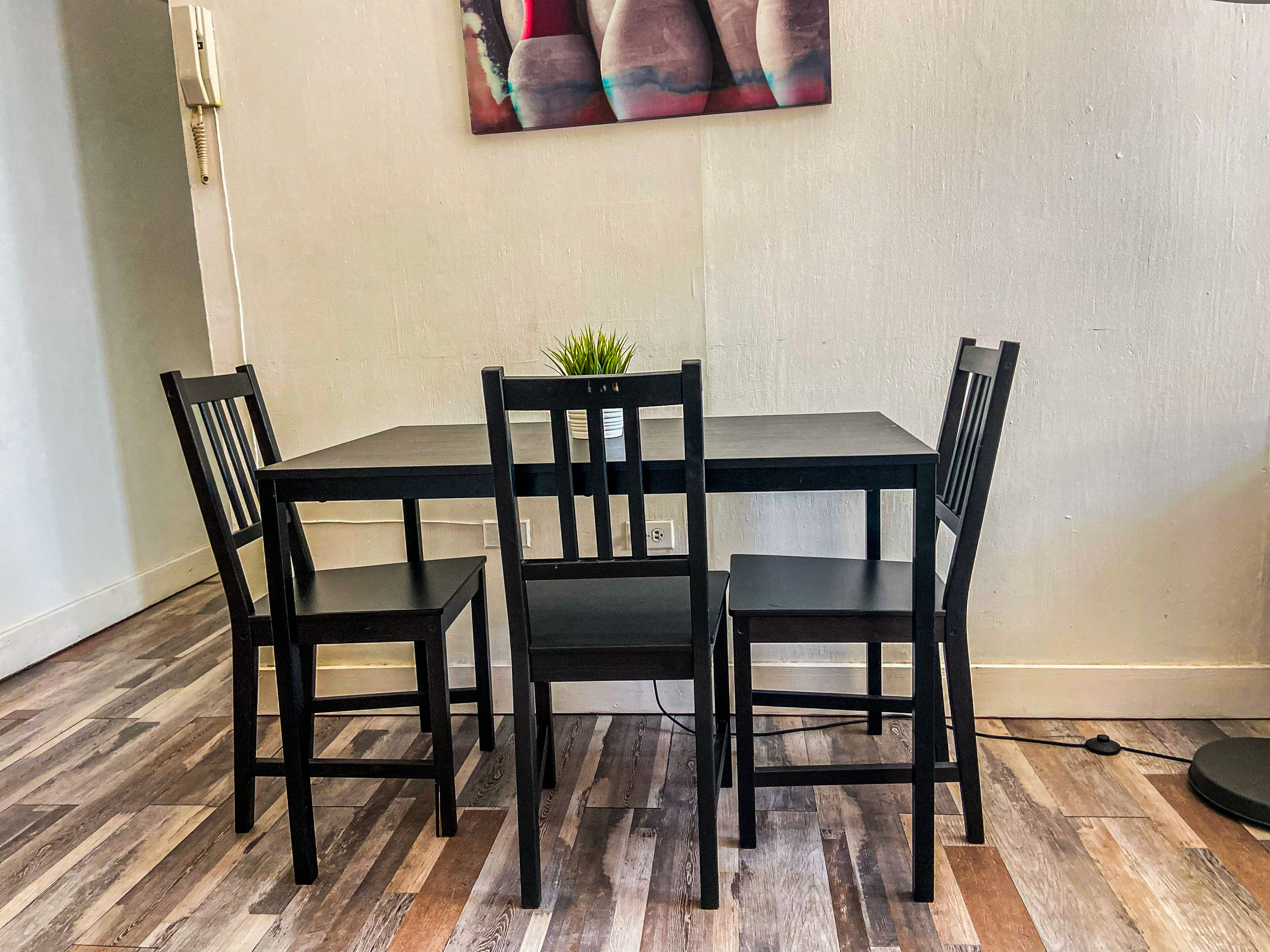A dining area with a rectangular table and four black chairs.