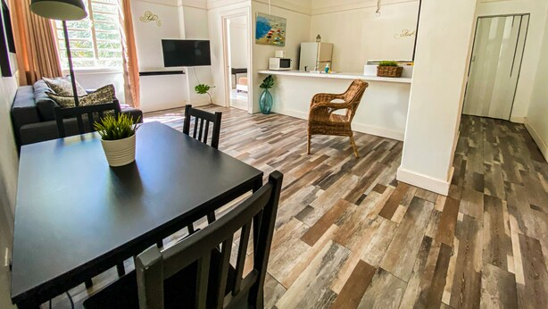 Un espace de vie moderne comprenant un coin repas, une cuisine et un coin salon.