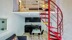 A compact living space with a kitchen, dining area, and a red spiral staircase. - Gladiolas 2101 (Ponce)